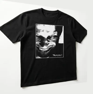 Black and white abstract graphic of Aphex Twin face with printed text. — printed on a unisex t-shirt (angled view)
