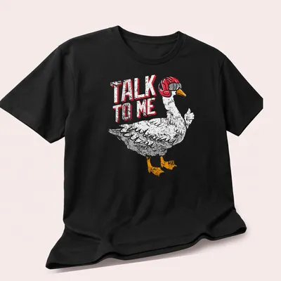 Cartoonish aviator goose with goggles and the text 'TALK TO ME' — printed on a unisex t-shirt (angled view)