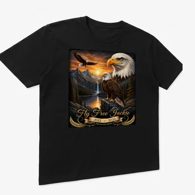 Realistic bald eagle soaring with tribute text for Jackie, featuring gold and brown tones. — printed on a unisex t-shirt (angled view)