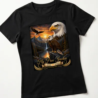 Realistic bald eagle soaring with tribute text for Jackie, featuring gold and brown tones. — printed on a women's shirt