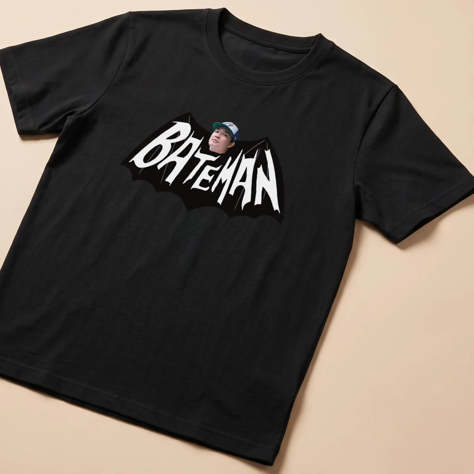 Bold Bateman text in black and white on a graphic — printed on a unisex t-shirt