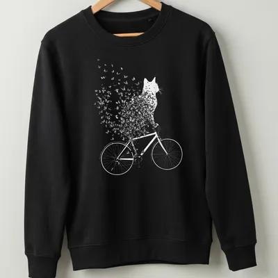 Whimsical line-art of a cat on a bicycle surrounded by butterflies in black and white — printed on a unisex sweatshirt