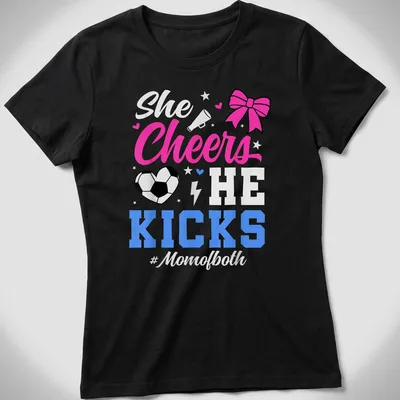 Colorful shirt with text 'She Cheers He Kicks #Momofboth' and graphics of pom-poms and a soccer ball — printed on a women's shirt
