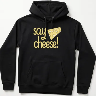 Playful cartoon cheese with text 'say cheese!' in yellow tones — printed on a unisex hoodie