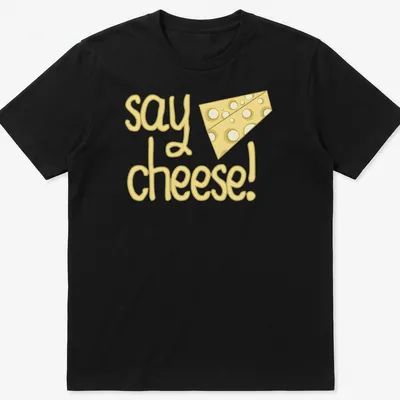 Playful cartoon cheese with text 'say cheese!' in yellow tones — printed on a unisex t-shirt
