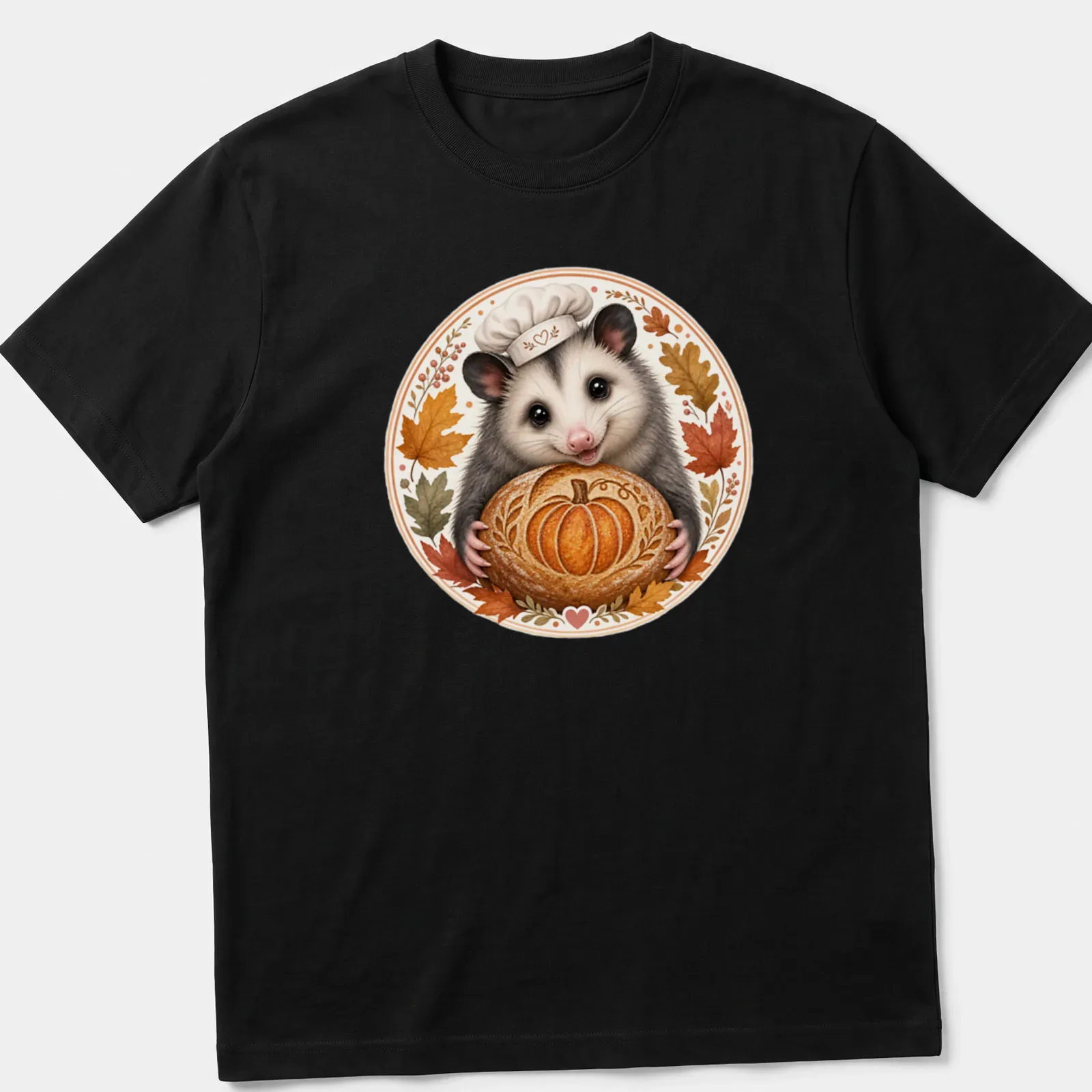 Whimsical illustration of a cute possum baker holding a pumpkin-shaped sourdough — printed on a unisex t-shirt