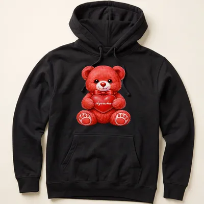 Realistic print of a cute red teddy bear holding a pink heart with the name Ayousha — printed on a unisex hoodie
