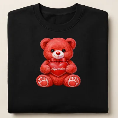 Realistic print of a cute red teddy bear holding a pink heart with the name Ayousha — printed on a unisex sweatshirt