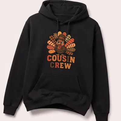 Cartoon turkey design with 'Cousin Crew' text, bright colors for Thanksgiving. — printed on a unisex hoodie