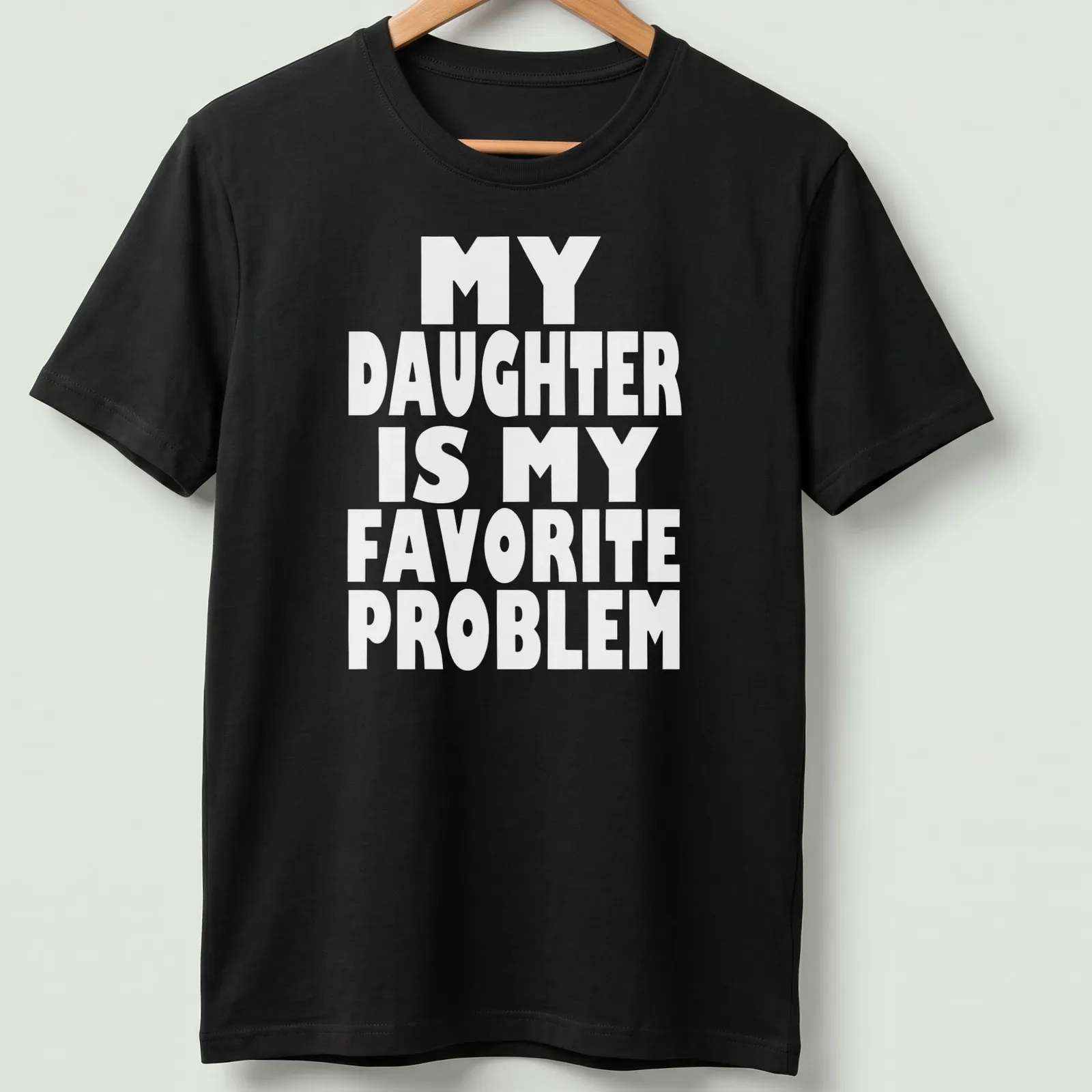 Bold typography t-shirt with the phrase 'MY DAUGHTER IS MY FAVORITE PROBLEM' in white. — printed on a unisex t-shirt