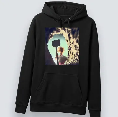 Distressed T-shirt featuring a whimsical doll face design in light blue and pink. — printed on a unisex hoodie