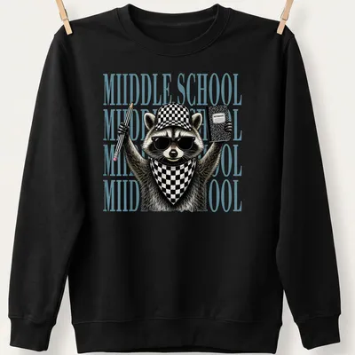 Detailed illustration of a feral raccoon with text reading 'MIIDDLE SCHOOL' in black and light blue — printed on a unisex sweatshirt