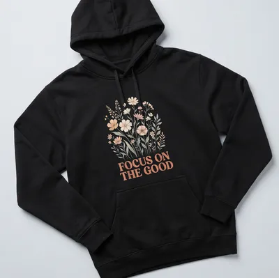 Floral line-art T-shirt featuring the phrase Focus On The Good above wildflowers — printed on a unisex hoodie
