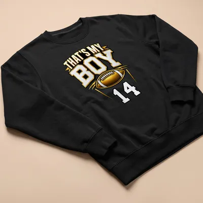 Bold typography t-shirt with text 'That's My Boy 14' in gold, black, and white — printed on a unisex sweatshirt