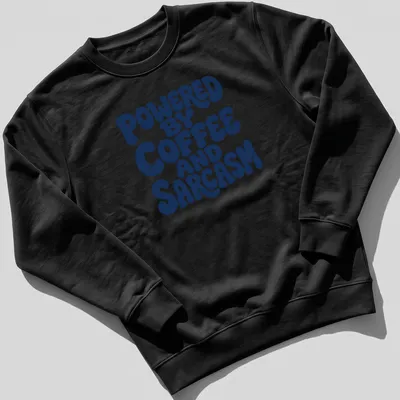 Bold typography shirt with the quote 'Powered By Coffee And Sarcasm' in navy and white — printed on a unisex sweatshirt