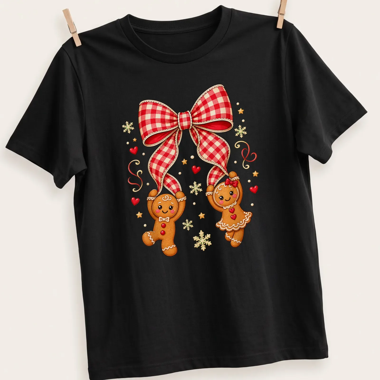 Kawaii gingerbread couple under a red plaid bow in festive colors — printed on a unisex t-shirt