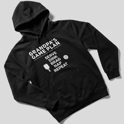 Bold typography design with the phrase Grandpa's Game Plan Serve Dink Brag Nap Repeat — printed on a unisex hoodie