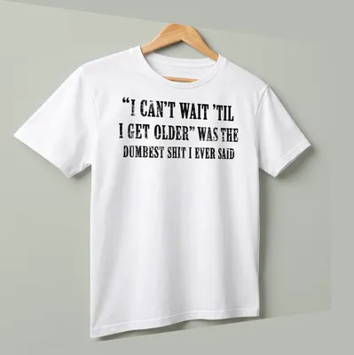 Distressed black text on white tee humorously reflecting on aging. — printed on a unisex t-shirt (angled view)