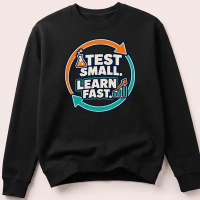 Bold graphic tee with 'TEST SMALL. LEARN FAST.' and laboratory flask illustration — printed on a unisex sweatshirt