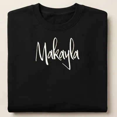 Elegant script t-shirt featuring the name Makayla in gold on white — printed on a unisex sweatshirt