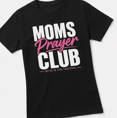 Bold typography t-shirt with 'MOMS Prayer CLUB WE'RE IN THIS TOGETHER' text in pink and white — printed on a women's shirt