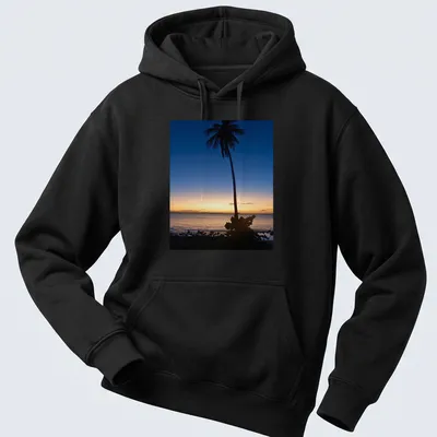 Silhouette of a palm tree against a colorful sunset horizon. — printed on a unisex hoodie