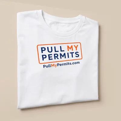 Bold typography shirt with 'Pull My Permits' text in orange and navy blue — printed on a unisex t-shirt (angled view)