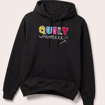 Colorful patchwork design with floral patterns spelling Quilt Whisperer — printed on a unisex hoodie