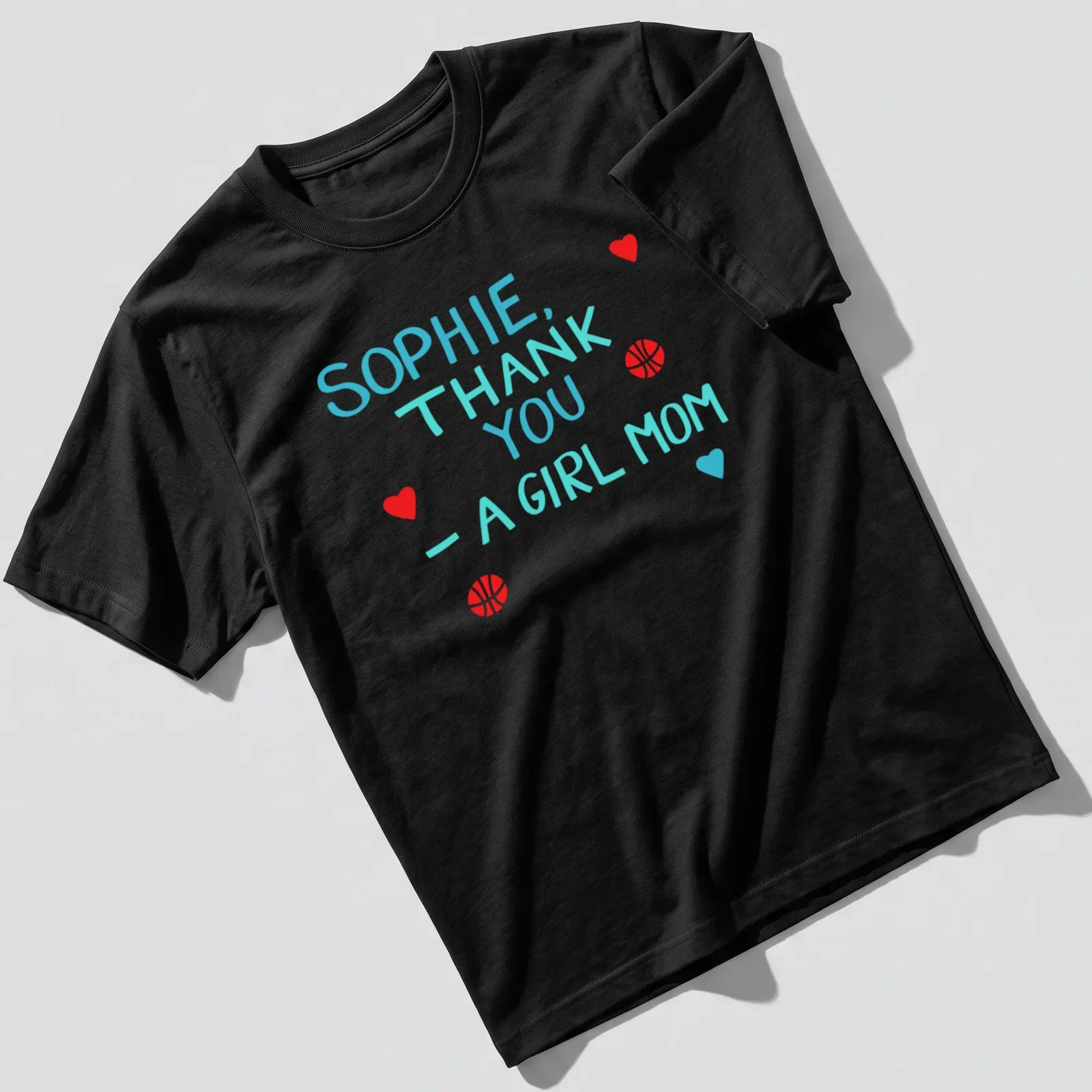 Playful t-shirt with basketball graphics and colorful text celebrating girl moms — printed on a unisex t-shirt