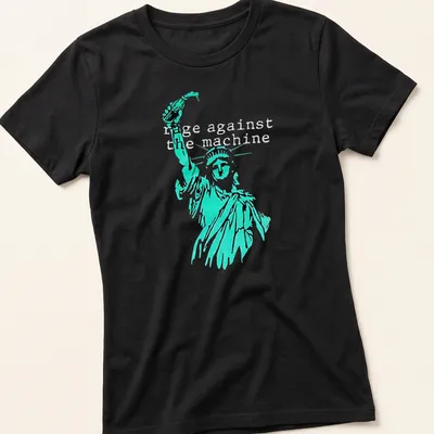 Vintage-style tee featuring the Statue of Liberty with Rage Against the Machine text in turquoise and black — printed on a women's shirt