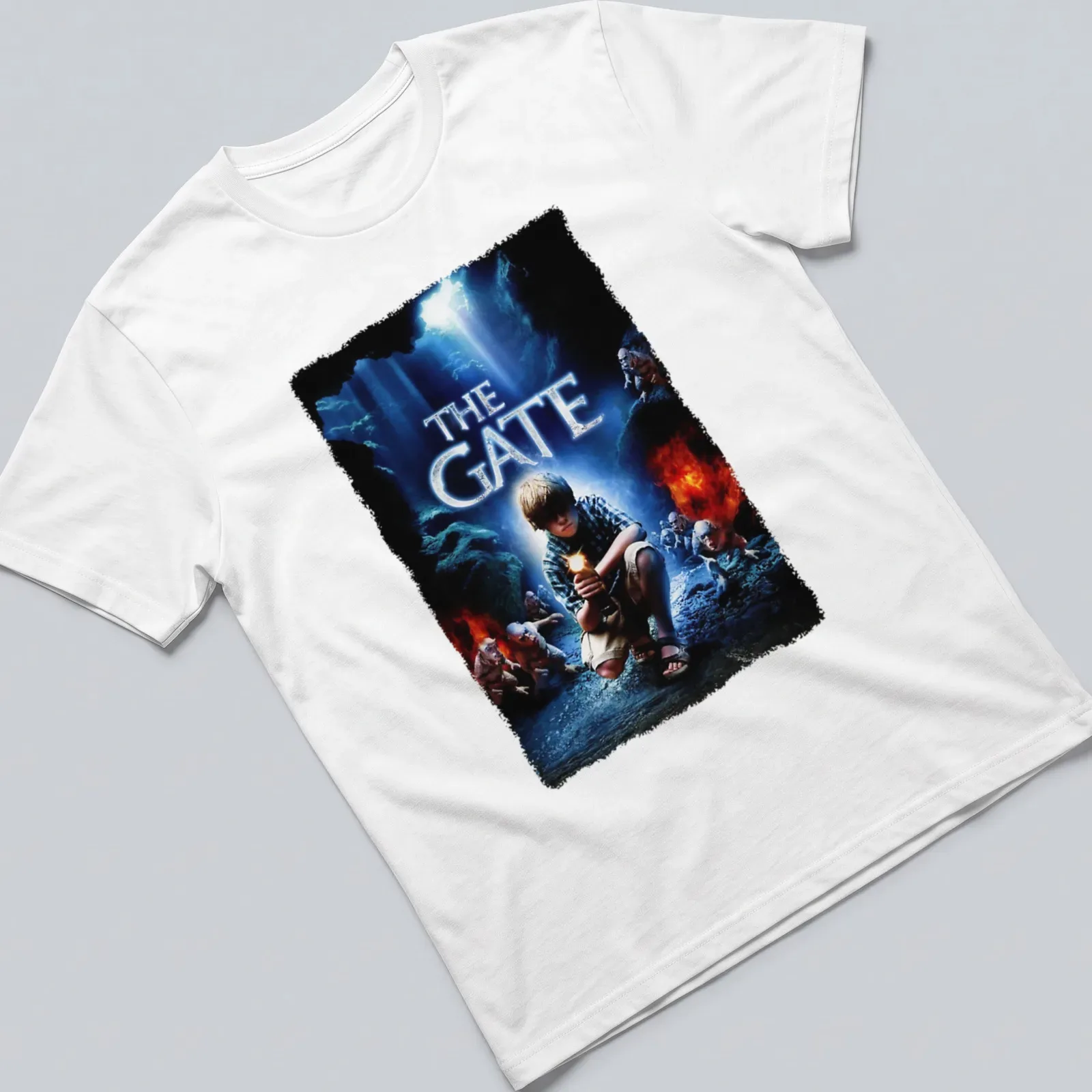Horror movie poster-style t-shirt featuring a boy with a flashlight and the text 'THE GATE' — printed on a unisex t-shirt