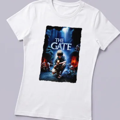 Horror movie poster-style t-shirt featuring a boy with a flashlight and the text 'THE GATE' — printed on a women's shirt