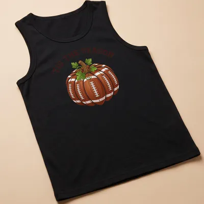 Cartoon pumpkin with footballs and the text 'TIS THE SEASON' in festive colors — printed on a tank top