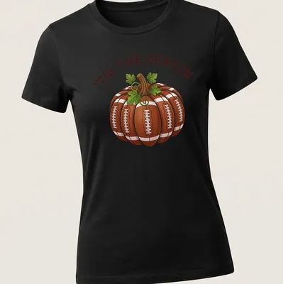 Cartoon pumpkin with footballs and the text 'TIS THE SEASON' in festive colors — printed on a women's shirt