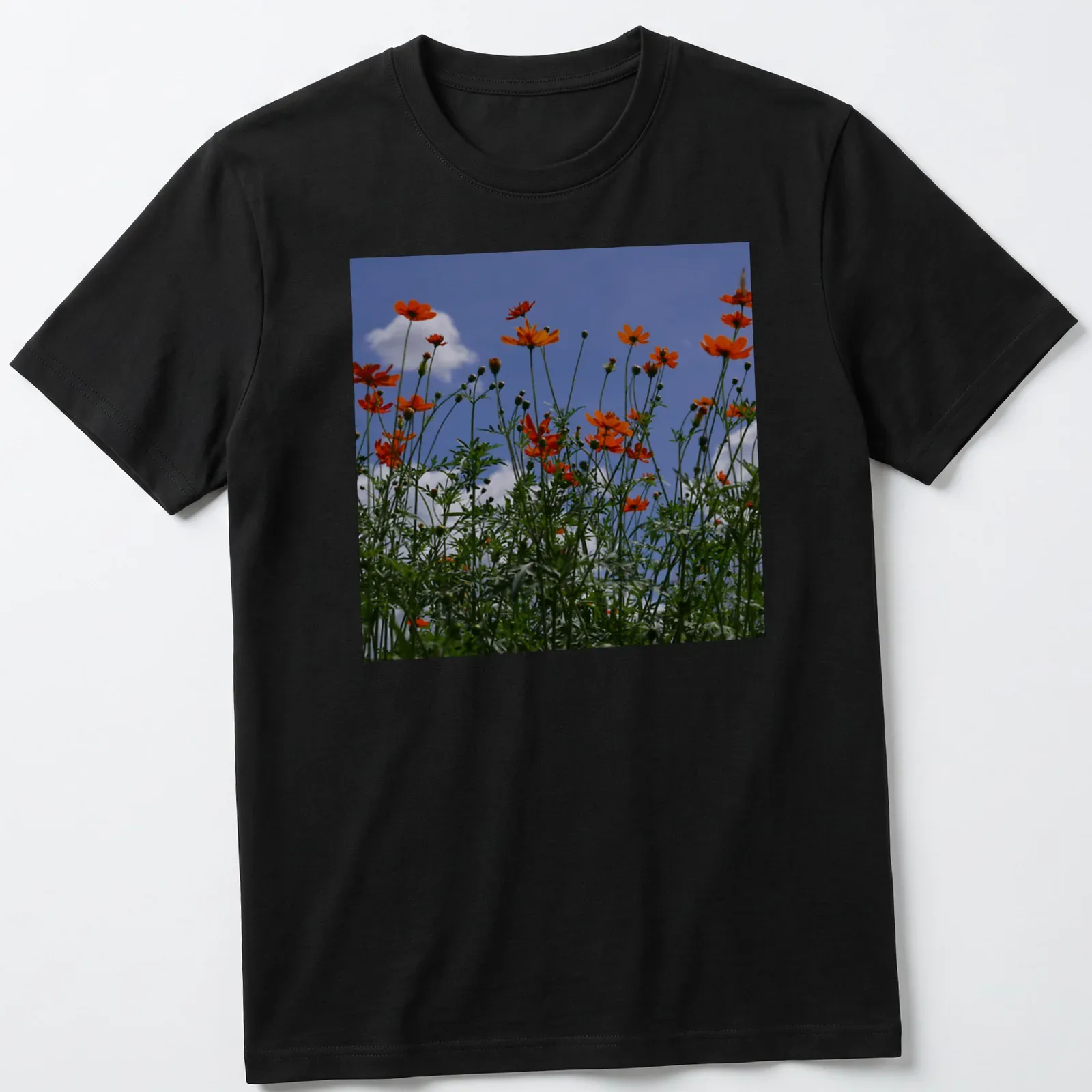 Photographic print of vibrant orange wildflowers against a blue sky — printed on a unisex t-shirt