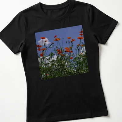 Photographic print of vibrant orange wildflowers against a blue sky — printed on a women's shirt